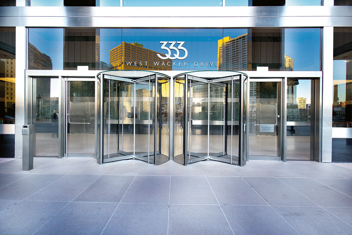 A photo of an architectural building product. An exterior entrance to a large building, showing glass revolving doors.