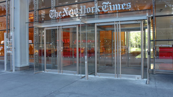 A photo of an architectural building product. An exterior entrance to a large building (The New York Times headquarters building), showing glass doors.
